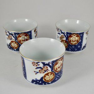 Vintage inscribed Japanese tea cups with gold rim and repeating patterns.
